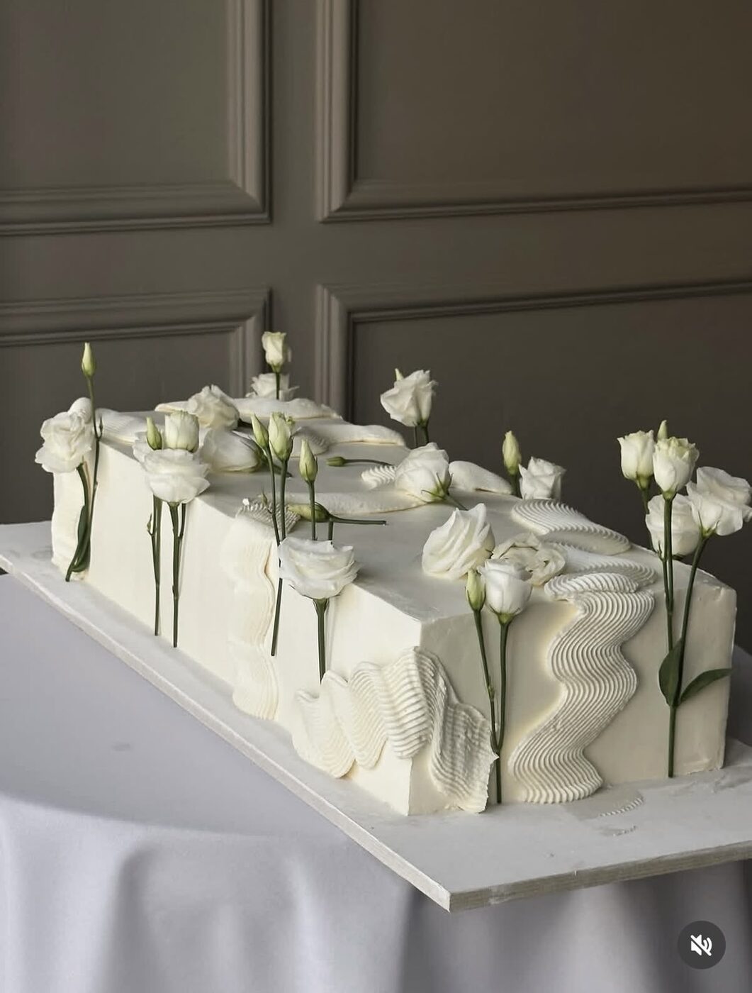 Two-tier white wedding cake covered with sugar pearls