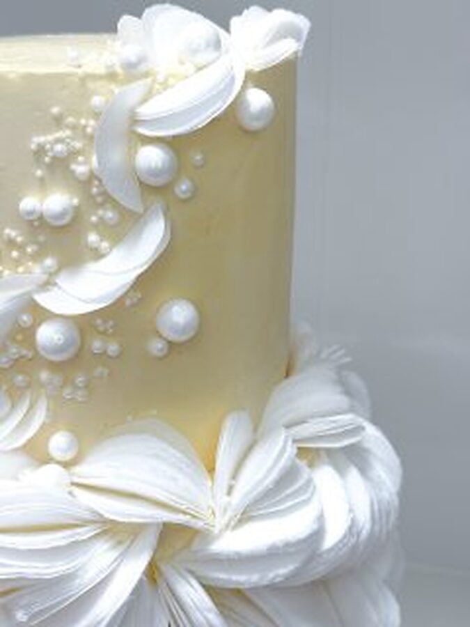 Detail of sugar pearls and wafer ruffles on a champagne wedding cake