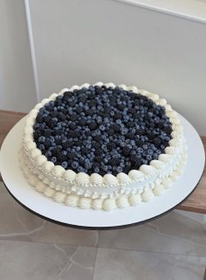 Round Medovik cake topped with fresh blueberries