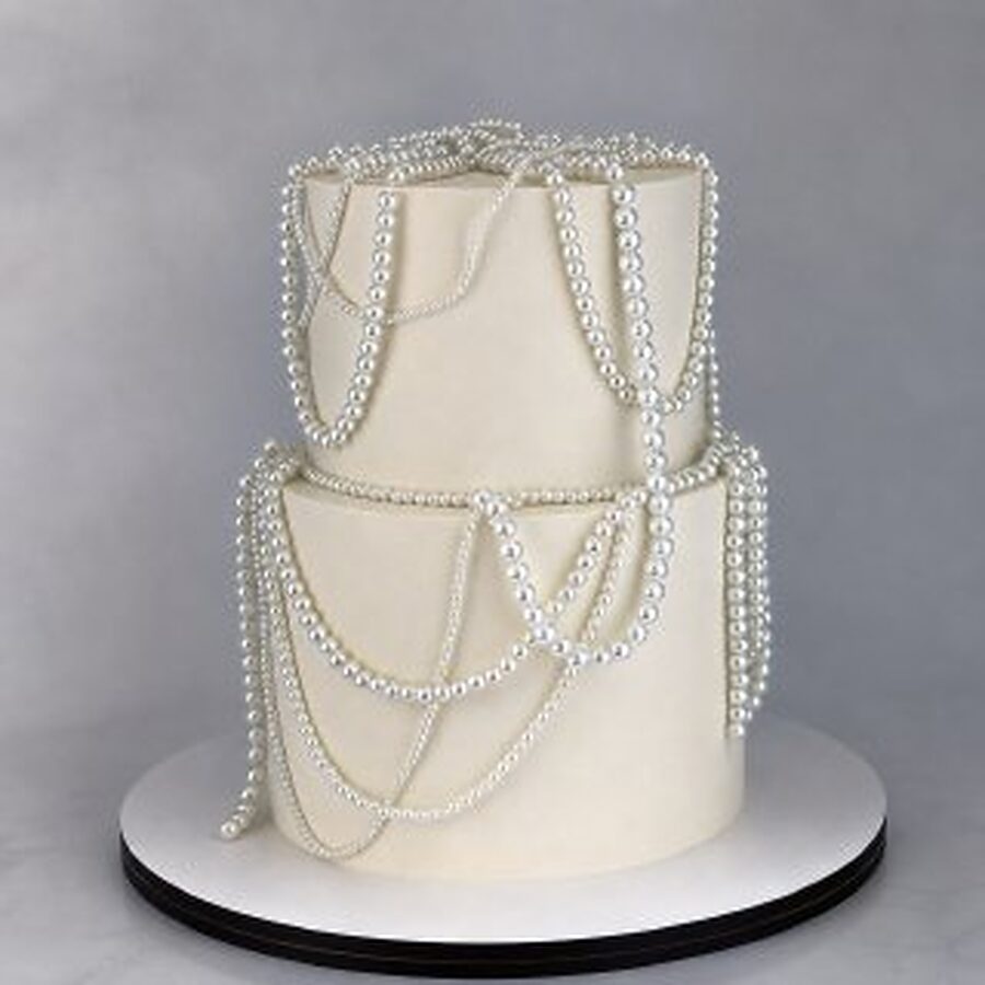 Two-tier wedding cake draped with strands of sugar pearls